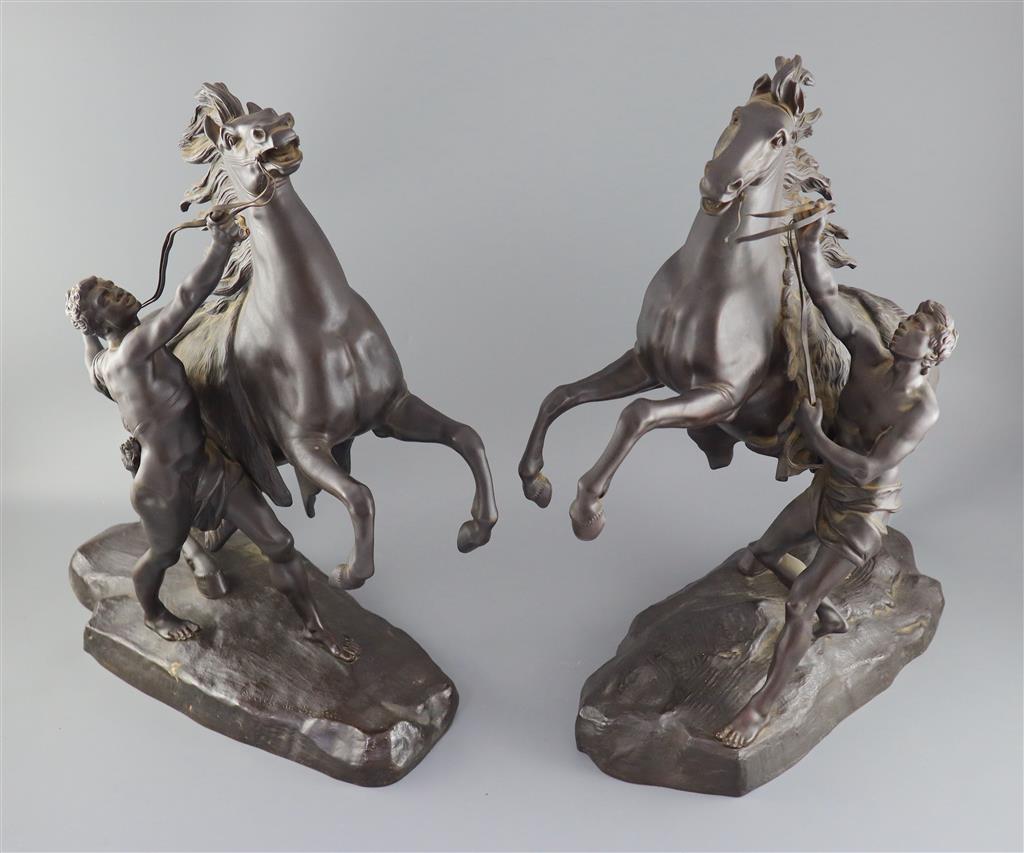 After Guillaume Coustou the Elder (French 1677-1746). A pair of bronze Chevaux de Marly, height 19in.